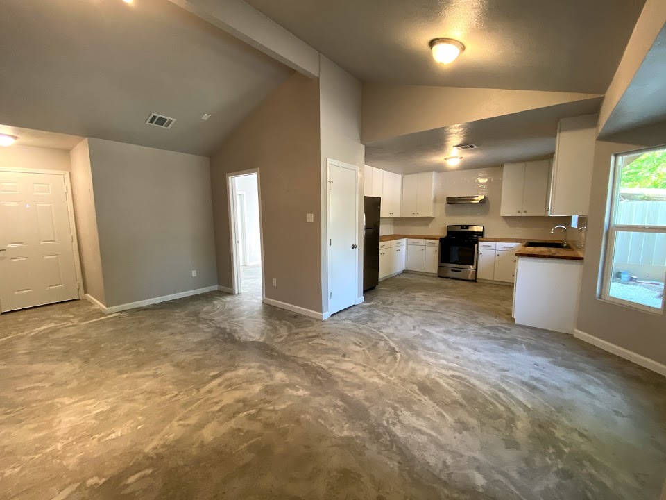A renovated open kitchen and living area with new cabinets and appliances